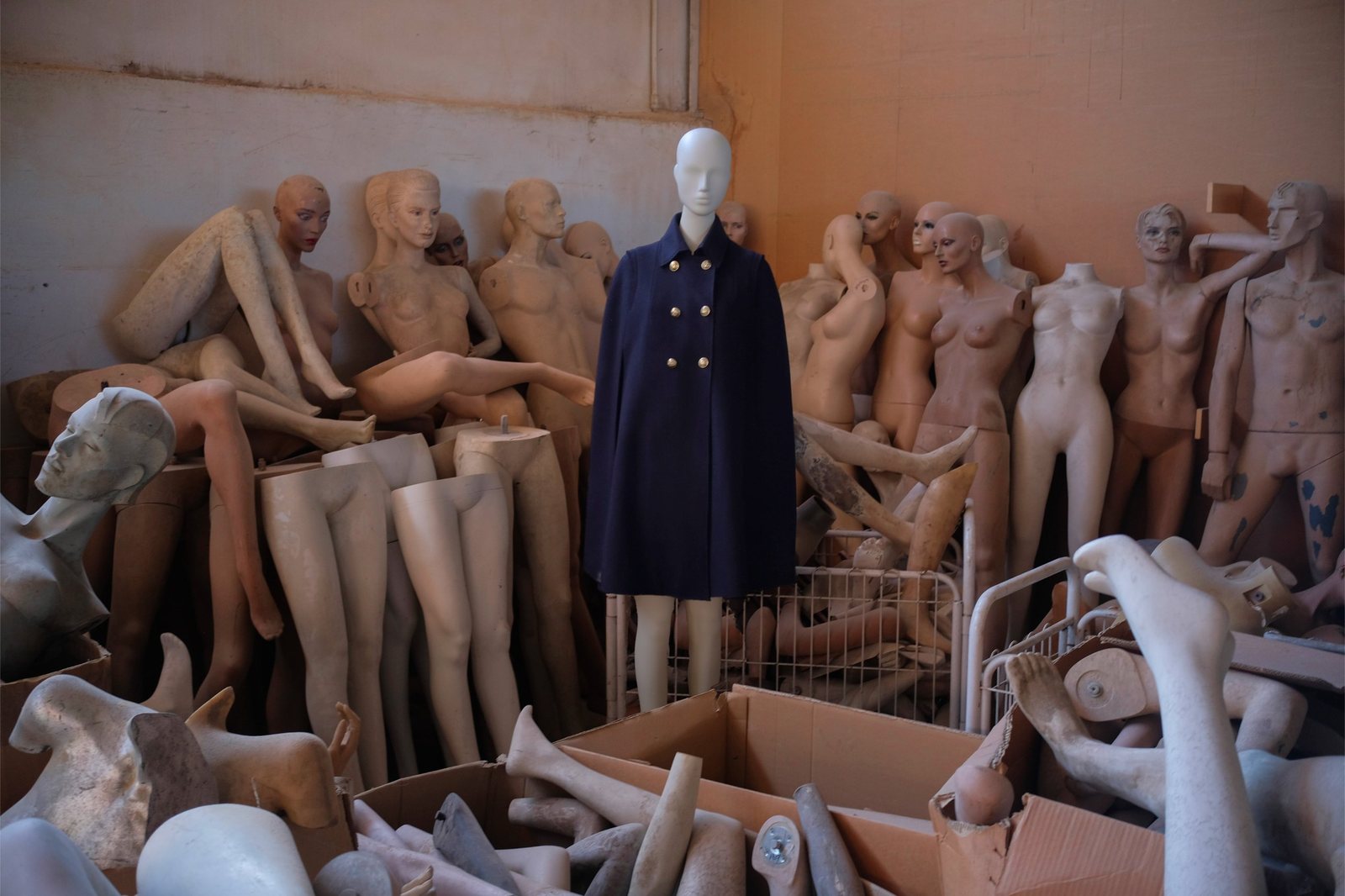 navy cape on a mannequin in a storeroom